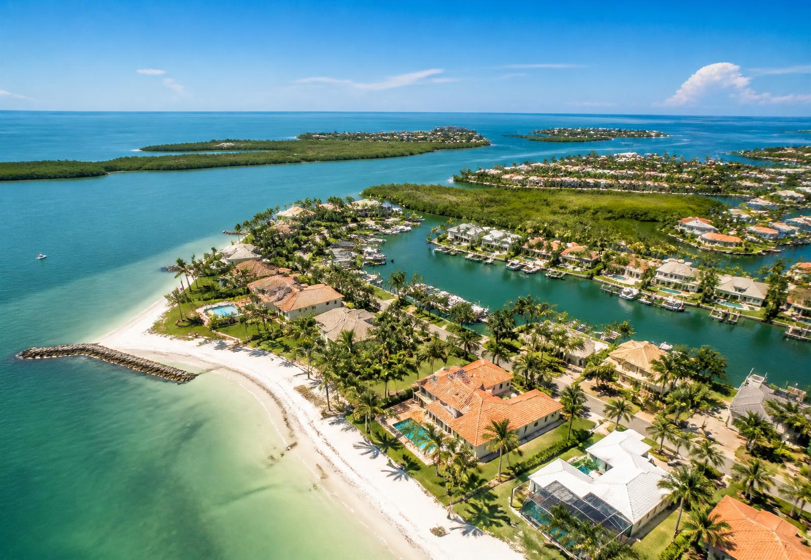 Aerial view of a Southwest Florida Gulf Coast neighborhood with beach, canals, and boat docks